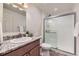 Well-lit bathroom featuring a modern vanity and a glass-enclosed walk-in shower at 25126 E Bayaud Pl, Aurora, CO 80018