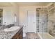 Well-lit bathroom featuring a granite countertop, decorative floor tiles, and glass shower enclosure at 25126 E Bayaud Pl, Aurora, CO 80018