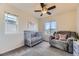 Bedroom featuring a window view, gray crib, soft carpet, and cozy gray armchair at 25126 E Bayaud Pl, Aurora, CO 80018