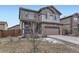 Two-story home showcasing a stone facade, neutral siding, an attached garage, and a well-maintained front lawn at 25126 E Bayaud Pl, Aurora, CO 80018