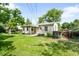 Spacious backyard with a covered patio, grassy lawn, and a charming home exterior at 4616 E Yale Ave, Denver, CO 80222
