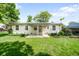 Backyard featuring a covered patio, green lawn, and a charming home exterior at 4616 E Yale Ave, Denver, CO 80222