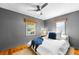 Bedroom with gray walls, hardwood floors, two windows, and a plush bed with throw blanket at 4616 E Yale Ave, Denver, CO 80222