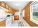 Galley kitchen featuring white appliances, white tile flooring, and wooden cabinets at 4616 E Yale Ave, Denver, CO 80222