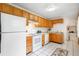 Galley kitchen featuring white appliances, white tile flooring, and wooden cabinets at 4616 E Yale Ave, Denver, CO 80222