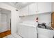 Functional laundry room with washer, dryer, utility sink and cabinet space at 4616 E Yale Ave, Denver, CO 80222