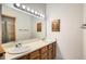 Bathroom with double sinks, a large vanity mirror, and cabinet storage at 8795 W Cornell Ave # 1, Lakewood, CO 80227
