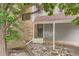 Townhome entrance featuring brick accents, siding, and mature landscaping at 8795 W Cornell Ave # 1, Lakewood, CO 80227