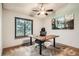 Office featuring an adjustable desk, ceiling fan, large window, and a decorative mountain art piece at 8795 W Cornell Ave # 1, Lakewood, CO 80227