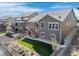 Landscaped backyard with wood fence, small patio, artificial turf area, and stone walkway to the main house at 8099 Arapahoe Peak St, Littleton, CO 80125