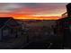 A backyard view captures a beautiful sunset over the landscape, featuring a well-maintained lawn and fencing at 8099 Arapahoe Peak St, Littleton, CO 80125