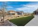 Spacious backyard featuring synthetic grass and tasteful rock and bush landscaping at 8099 Arapahoe Peak St, Littleton, CO 80125