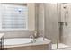 Contemporary bathroom with a soaking tub and shower featuring elegant tile work and modern fixtures at 8099 Arapahoe Peak St, Littleton, CO 80125