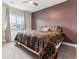 A bedroom featuring a patterned bedspread, a large window, and stylish purple walls at 8099 Arapahoe Peak St, Littleton, CO 80125