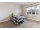 Bright bedroom with a large window and a twin bed featuring a checkered comforter at 8099 Arapahoe Peak St, Littleton, CO 80125