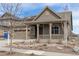 Charming home with covered porch, two-car garage, and low maintenance landscaping with blue sky at 8099 Arapahoe Peak St, Littleton, CO 80125