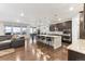 Open concept kitchen features stainless appliances, large island, hardwood floors, and adjacent seating area at 8099 Arapahoe Peak St, Littleton, CO 80125