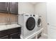 Functional laundry room features a washer, dryer, sink, and ample cabinet space at 8099 Arapahoe Peak St, Littleton, CO 80125