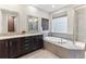 Luxurious main bathroom featuring double sinks, a soaking tub, a glass-enclosed shower, and modern fixtures at 8099 Arapahoe Peak St, Littleton, CO 80125