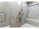 Shower featuring gray tiling, built-in bench, and a hand-held shower head at 8099 Arapahoe Peak St, Littleton, CO 80125