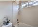 Bright bathroom showcasing a tiled shower, clean white fixtures, and a window for natural light at 10551 Redcone Way, Highlands Ranch, CO 80130