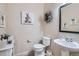 Bathroom featuring toilet, sink, and decorative artwork, with soft, neutral colors at 10551 Redcone Way, Highlands Ranch, CO 80130