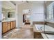 Bathroom with double sinks, soaking tub and an adjoining room visible through the doorway at 10551 Redcone Way, Highlands Ranch, CO 80130