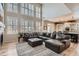 Bright living room featuring large windows with shutters, a fireplace, and a spacious sectional couch at 10551 Redcone Way, Highlands Ranch, CO 80130