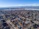 Scenic aerial view of a residential neighborhood with a lake, cityscape, and mountains in the background at 2650 Perry St, Denver, CO 80212