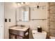 Neat bathroom featuring a vanity with a sink, a toilet, and a mirrored cabinet for storage at 2650 Perry St, Denver, CO 80212