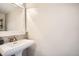 Clean and bright bathroom with a pedestal sink, a large mirror, and neutral walls at 2650 Perry St, Denver, CO 80212