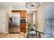 Cozy kitchen with stainless steel appliances, wood cabinets, and a glass table with modern light fixture at 2650 Perry St, Denver, CO 80212