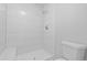 A modern bathroom with a glass shower, tile walls, and white fixtures at 12662 E Warren Dr # F, Aurora, CO 80014