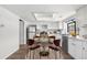 Eat-in kitchen features modern white cabinetry, stainless appliances, hardwood floors, and table for four at 12662 E Warren Dr # F, Aurora, CO 80014