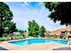 Community swimming pool, surrounded by lawn chairs, trees, and neighborhood townhomes at 12662 E Warren Dr # F, Aurora, CO 80014