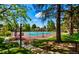 Beautifully landscaped tennis court surrounded by mature trees and green grass at 12662 E Warren Dr # F, Aurora, CO 80014