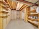 Unfinished basement with exposed ceiling, concrete walls, and built in wooden shelves at 8166 E Phillips Ave, Centennial, CO 80112