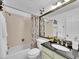 Well-lit bathroom featuring a bathtub with shower, modern vanity, and decorative wall accents at 8166 E Phillips Ave, Centennial, CO 80112