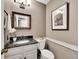 Cozy half bathroom featuring a granite countertop, framed mirror, and neutral wall color at 8166 E Phillips Ave, Centennial, CO 80112