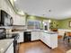 Bright kitchen with stainless steel appliances, granite countertops, and view into the dining room with fireplace at 8166 E Phillips Ave, Centennial, CO 80112