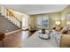 Cozy living room with hardwood floors, a plush rug, and abundant natural light from large windows at 8166 E Phillips Ave, Centennial, CO 80112