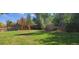 Lush backyard featuring a swing set and expansive green lawn with mature trees at 6892 Turnstone Ave, Castle Rock, CO 80104