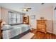 Bedroom with light pink walls, ceiling fan and wood floors features a sunny window and wood dresser at 6892 Turnstone Ave, Castle Rock, CO 80104