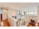 Bright, open landing with hardwood floors, white railings, and light fixtures at 6892 Turnstone Ave, Castle Rock, CO 80104