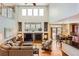 Sun-filled living room showcasing a fireplace, vaulted ceiling, and seamless transition to the dining area for modern living at 6892 Turnstone Ave, Castle Rock, CO 80104