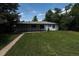 Backyard featuring a well-manicured lawn, covered patio area, and shade trees at 1032 Geneva, Aurora, CO 80010
