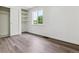 Bedroom with closet shelving, large window and wood-look floors at 1032 Geneva, Aurora, CO 80010
