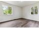 Bright bedroom with two large windows, grey wood-look flooring and neutral walls at 1032 Geneva, Aurora, CO 80010
