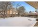 Snowy backyard with a wooden fence and bare trees at 12700 E Kentucky Pl, Aurora, CO 80012