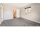 Neutral bedroom with gray carpet, window, and doorways to the closet and hallway at 12700 E Kentucky Pl, Aurora, CO 80012